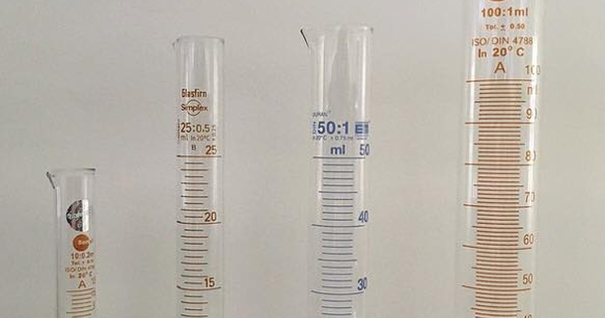 Four glass graduated measuring cylinders of increasing size showing volume markings