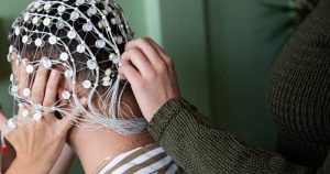 Dense EEG electrode array cap being fitted to a participant's head for a sleep study