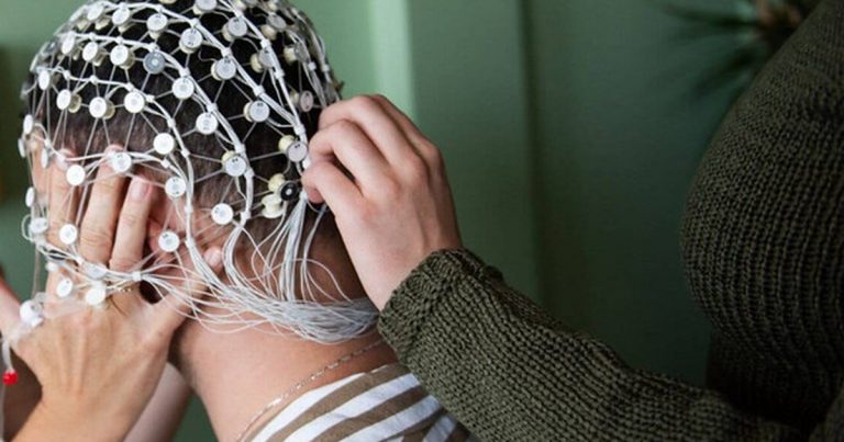 Dense EEG electrode array cap being fitted to a participant's head for a sleep study