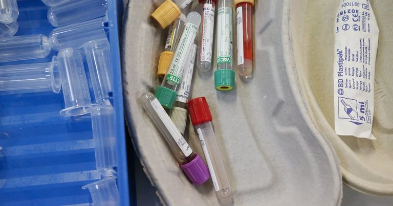 Assorted medical sample tubes with colored caps arranged in a moulded tray