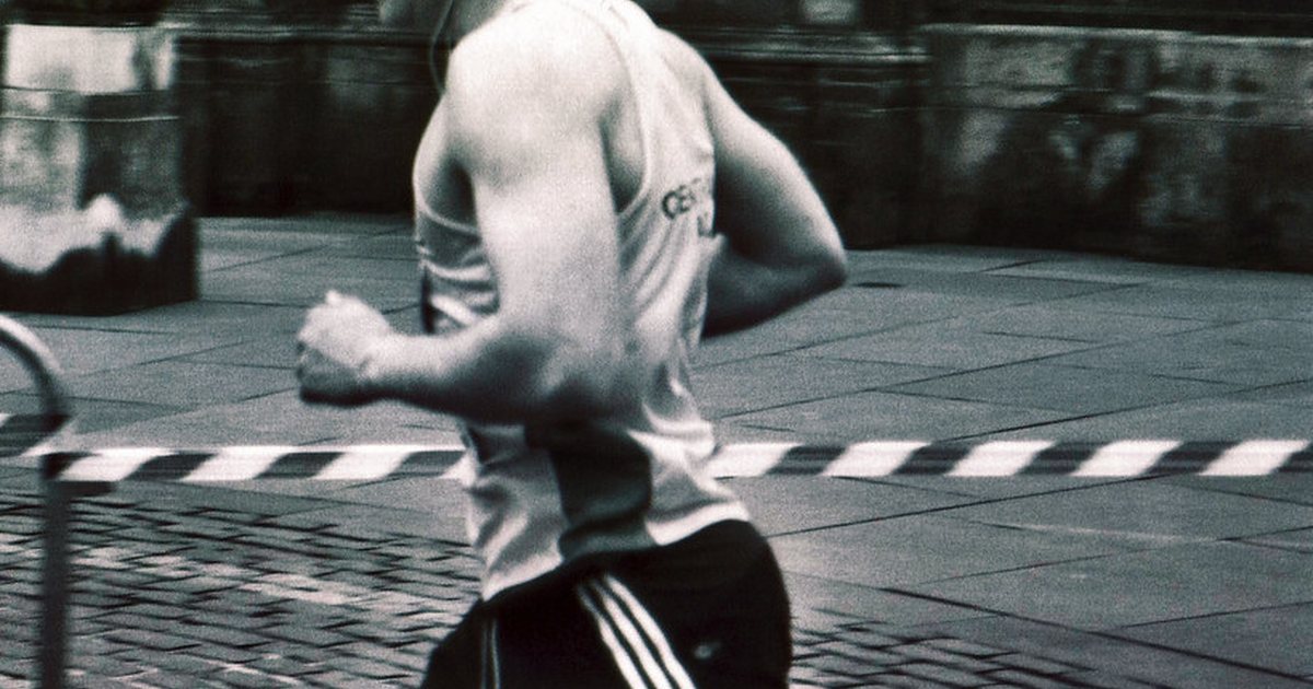 Runner in athletic clothing captured mid stride on a city street in black and white