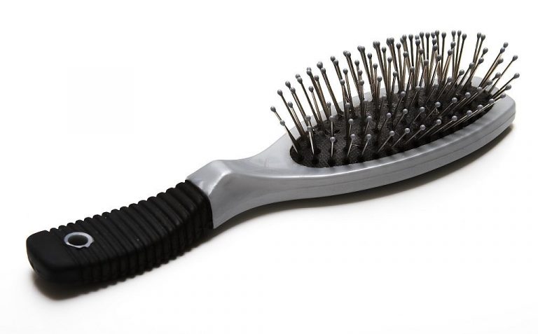 A hairbrush with metal bristles on a white background