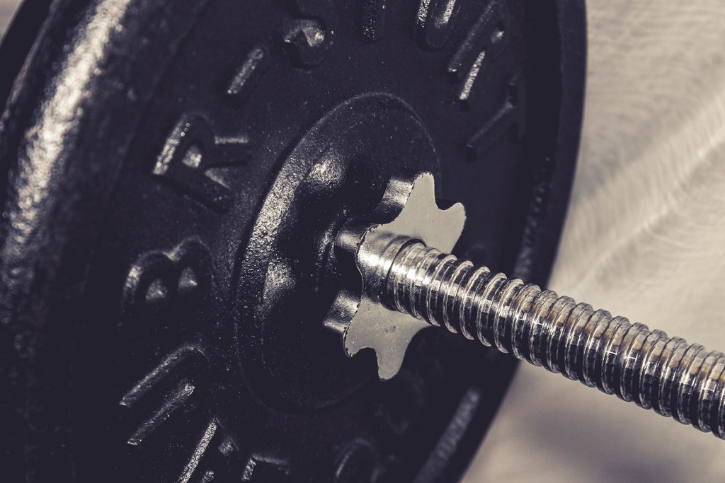 Close up of a cast iron weight plate on a barbell